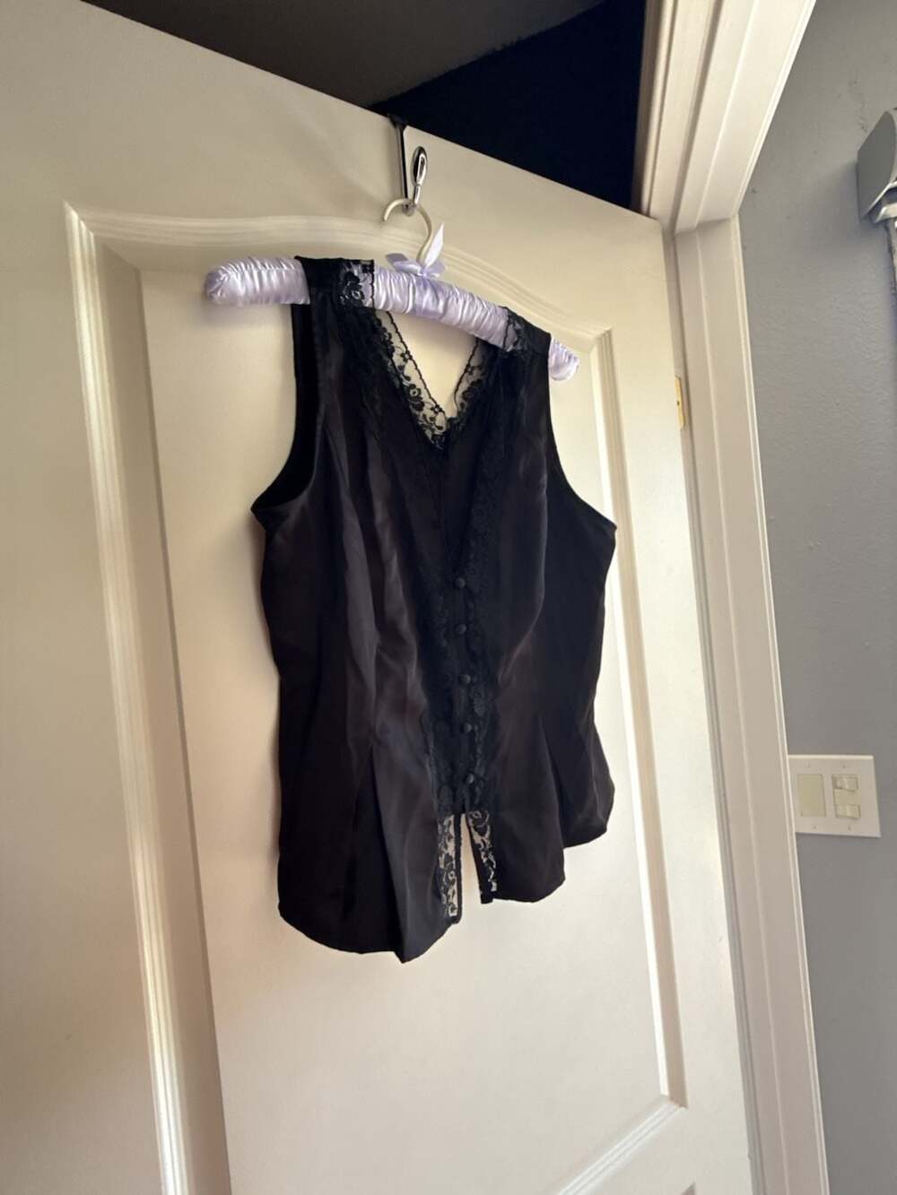 Black corset top with white floral lace details has...